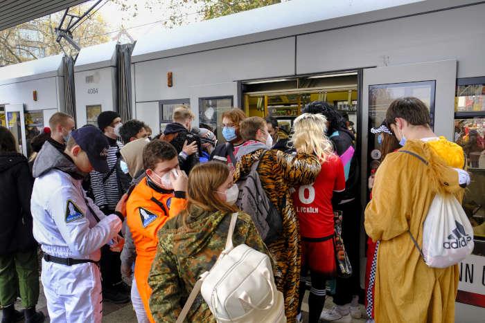 Kostmierte Fahrgste an der Haltestelle