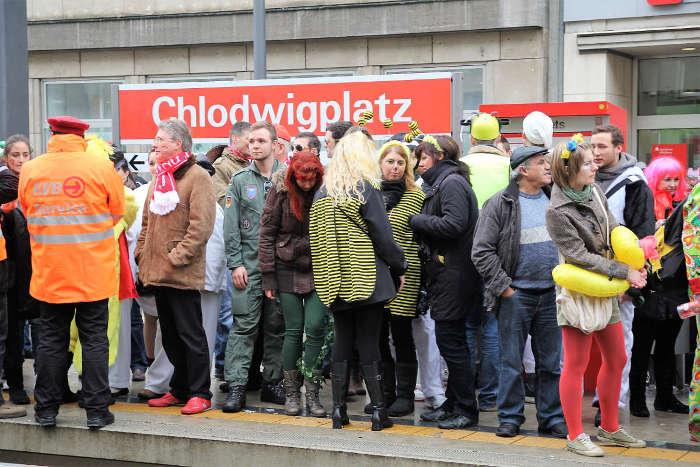 Kostmierte Fahrgste an der Haltestelle Chlodwigplatz